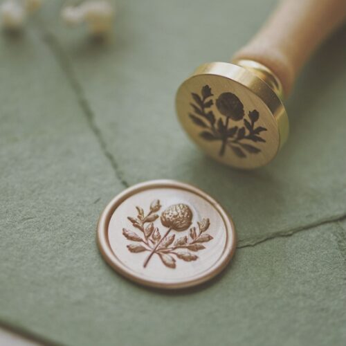 Brass wax seal head with chrysanthemum buds awaiting to bloom – top view on white background Close-up of chrysanthemum wax seal stamp head showing curled petal details Chrysanthemum bud wax seal impression on red sealing wax – example result